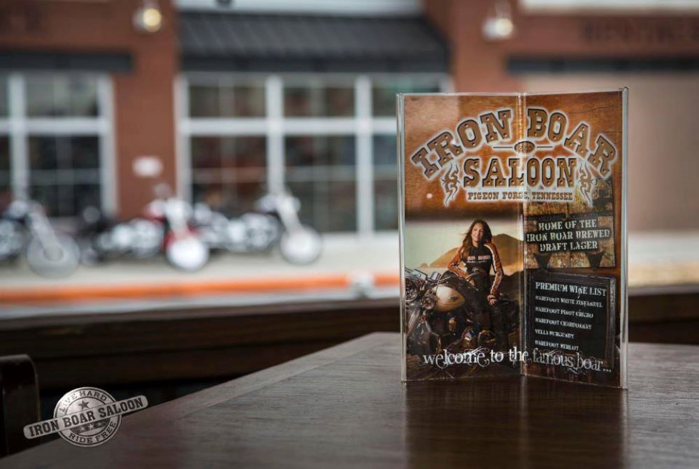 An advertisement for the Iron Boar Saloon sits on a table.